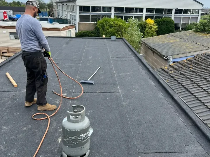 Opgeleverd plat dak van de uitbouw, met de aansluiting op het pannendak
