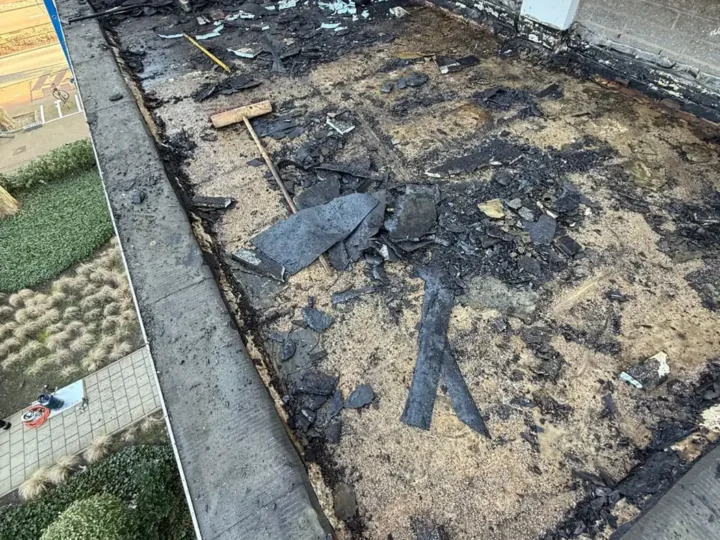 Oud dakpakket verwijderd tot op het beton, met resten natte isolatie