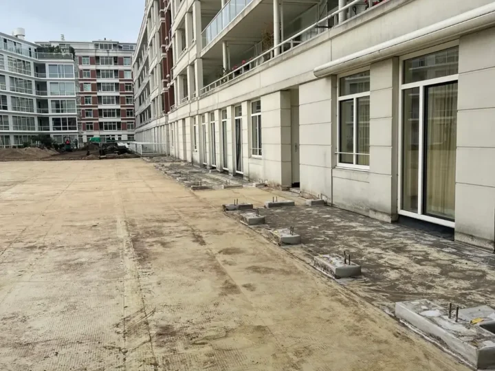 Kale ondergrond met sokkels langs de gevel na de sloop