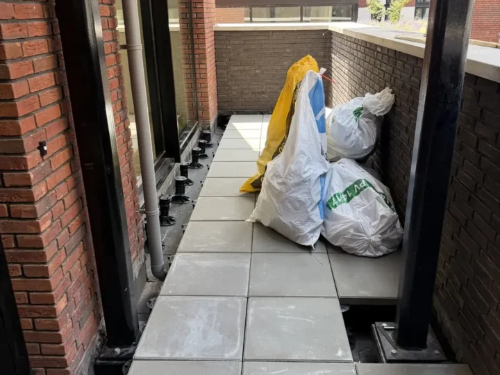 Tegels op verstelbare tegeldragers langs de galerij