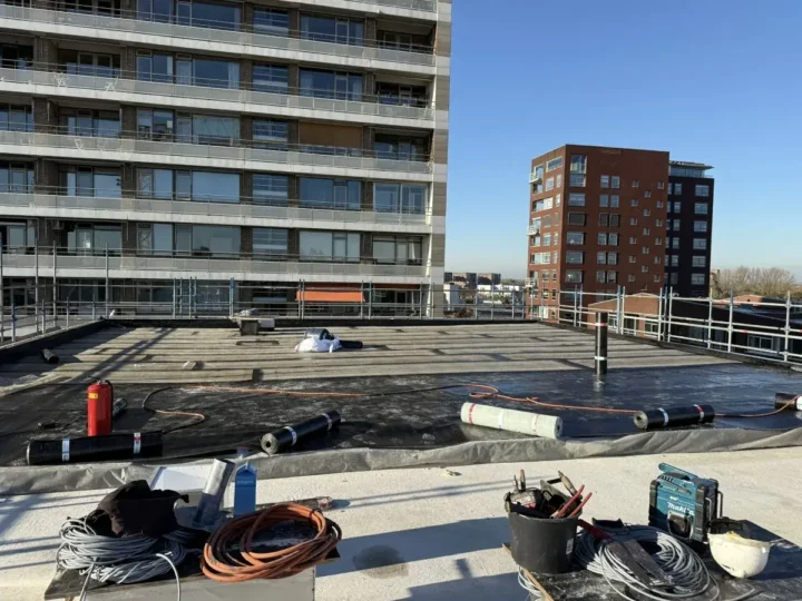 Hoogbouwdak met steigerhekken, nieuwe dakbedekking in uitvoering